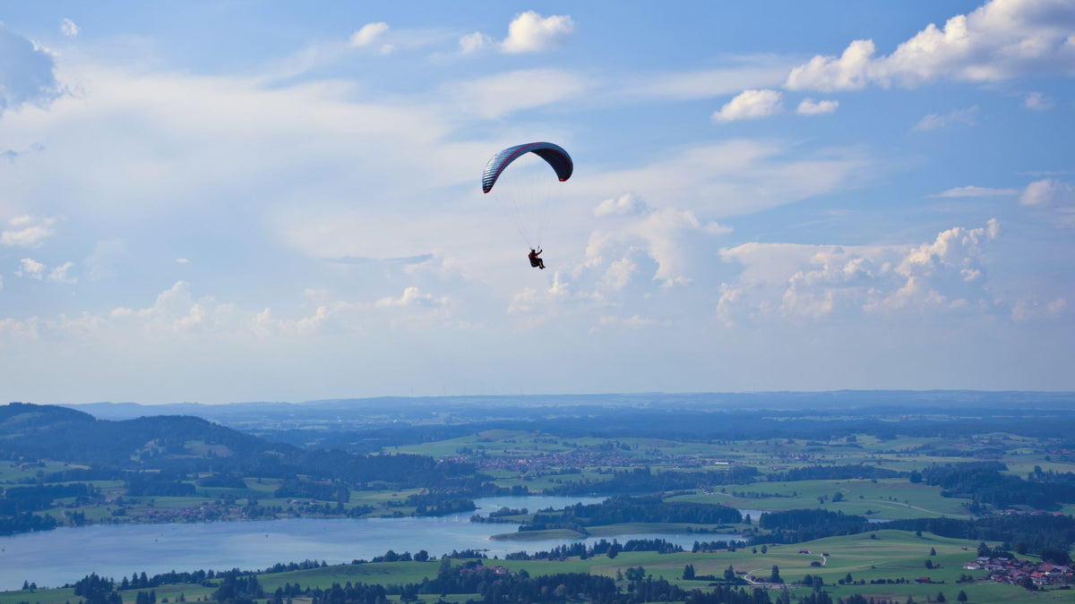 Gleitschirmflug über der Allgäuer Landschaft bei Buchenberg